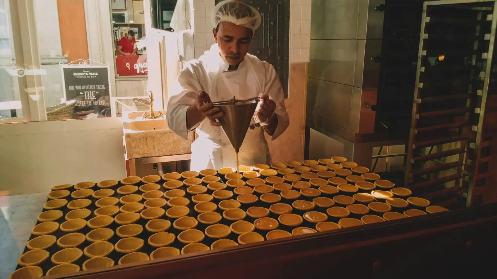 mangiare tra i quartieri di Lisbona, pasticcere che riempie di cioccolato le cialde